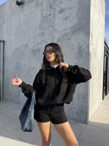 Campera tipo bomber de tela scuba con textura de gamuza, color negro, con cierre frontal, bolsillos laterales y puños elásticos.