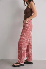 Jean de tiro alto y corte baggy con diseño barrel, en color rojo con estampado paisley blanco.