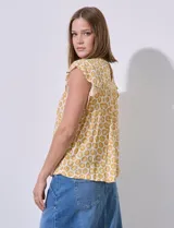 Blusa estampada color amarillo con flores blancas, de corte recto y mangas cortas con volados. Presenta frunces en la parte delantera y abertura con botón en la espalda. Marca Premise.