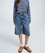 Bermuda jorts de jeans azul, corte ancho y largo por debajo de la rodilla, tiro medio con trabillas para cinturón y bolsillos traseros.