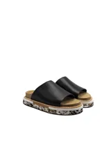 Sandalias negras de cuero con plataforma de corcho y suela con diseño moteado.