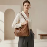 Bolso tipo hobo de eco cuero color marrón, con correa larga ajustable para llevar al hombro o cruzado. Presenta un bolsillo exterior frontal con cierre metálico en diagonal y un bolsillo pequeño con tapa y broche a presión.