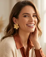 Caravanas de acero con baño de oro, con diseño de flor de pétalos definidos.