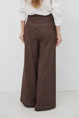 Pantalón de corte ancho y tiro alto, confeccionado en tejido con textura tipo espiga en color azul. Presenta pinzas en la cintura y costuras reforzadas.