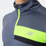 Camiseta de running de manga larga New Balance Accelerate Half Zip, color gris con franja horizontal en el pecho con detalles en negro y verde flúor. Cuenta con cierre de medio largo en el cuello y logo de la marca en el pecho.