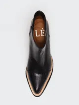 Botineta de cuero negro con puntera en textura croco y suela de madera clara. Diseño de caña corta con cierre lateral.