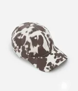 Gorra de sarga con estampado animal print de vaca, modelo dad hat con visera curva y ajuste trasero. Confeccionada en algodón sostenible.