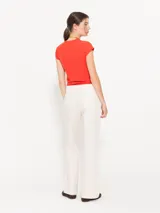 Pantalón de lanilla color crudo con finas rayas verticales de lurex, corte flare y cintura sastrera.