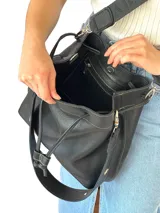 Bolso tote color marrón cuero, confeccionado en cuero genuino, con doble asa de mano y correa bandolera de tela con rayas beige y marrón.