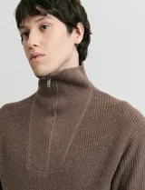 Remera de punto inglés con cuello alto y medio cierre metálico. Presenta mangas largas y puños en punto canalé.