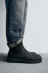 Bota tipo Chelsea de piel con acabado mate, diseño de horma redonda, elásticos laterales y suela track con volumen.
