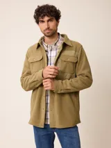 Sobrecamisa de polar color verde militar, con cierre frontal y botones a presión. Presenta bolsillos frontales con solapa y detalles en tela técnica en la parte superior y puños.