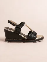 Sandalia de plataforma corrida color negro con detalles dorados, confeccionada en cuero con tiras acolchadas, detalle metálico en el empeine y tira ajustable con hebilla al tobillo.