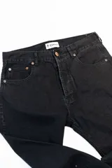 Jean negro de corte clásico con cinco bolsillos, botones color cobre y confeccionado en algodón 100% sin elastano.