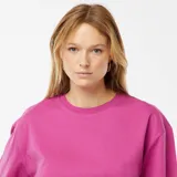 Camiseta rosa de cuello redondo y corte oversize con mangas cortas con dobladillo.