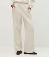 Pantalón wide leg de algodón y poliéster, color beige, con cintura elástica y detalle de costuras verticales frontales.