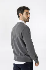 Sweater de algodón con escote en V y acabado stone wash, de manga larga con puños y ruedo acanalados.