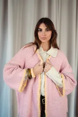 Saco oversize de tejido de punto en color rosa, con mangas caídas y detalles de bordado a mano en contraste en los bordes y costuras.