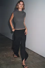 Chaleco de punto confeccionado en mezcla de lana color gris. Presenta cuello redondo, manga sisa con detalle de pliegues en los hombros y un bajo ancho en punto elástico que entalla la cintura.