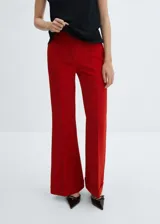 Pantalon de vestir color rojo, de corte flare con tiro medio. Presenta costuras verticales frontales, bolsillos laterales y ruedo con dobladillo ancho.