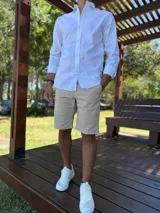 Camisa de manga larga color blanco, de corte clásico y cierre frontal con botones.
