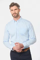 Camisa celeste lisa de corte clásico con cuello abotonado y bolsillo en el pecho.