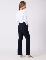 Jean de tiro alto con corte bootcut, ajustado en cadera y muslos con una sutil apertura desde la rodilla. Presenta diseño clásico de cinco bolsillos, cierre con botón y costuras en contraste. Su diseño posterior incluye costuras estratégicas para un efecto de realce en la silueta.