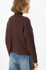 Sweater color crudo con cuello alto y diseño de tejido panal.