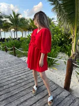 Vestido corto verde manzana de lino, con escote en V con volados y mangas abullonadas.