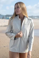 Campera estilo cazadora color arena, confeccionada 100% en cuero ovino. Hecha a mano en Uruguay, con cinta ajustable oculta en cintura para entallar, bolsillos a los costados y charreteras en hombros.