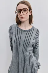 Sweater de punto color gris con diseño de rayas verticales oscuras, cuello redondo y calce relajado de mangas largas.