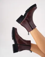 Botas Kiev de cuero vacuno color marrón, con suela de goma negra tipo track. Tienen cierre YKK en el lado interno y elástico en el lado externo. La punta es redonda y ancha.