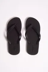 Ojota de hombre marca Mistral, color blanco con detalles de líneas negras en el borde de la suela. Presenta textura rayada en la base y logo de la marca en relieve tanto en la plantilla como en las tiras.