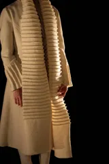 Tapado largo color crudo, confeccionado en lana merino afieltrada. Presenta cuello alto y guarda tejida en el cuello y ruedo. Tiene un estampado de una luna en la espalda.