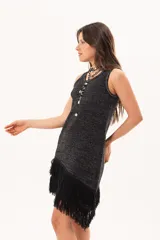 Vestido corto de tejido con hilo combinado con lúrex, de silueta recta y escote redondo, sin mangas, con flecos en el ruedo dispuestos en diagonal.