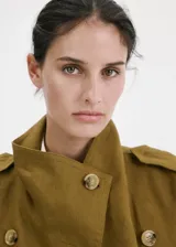 Chaqueta corta de lino color verde militar, con cuello solapa ancho, doble botonadura frontal y bolsillos laterales.
