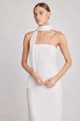 Vestido midi blanco de corte recto, con cuello halter y abertura en la espalda. Incluye lazo fino al cuello.