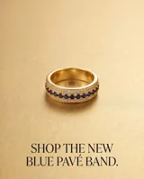 Anillo de bronce con baño de oro, diseño de banda ancha con una hilera central de circonias azules y hileras laterales de circonias transparentes.