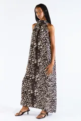 Vestido largo con cuello halter y estampado animal print combinado de leopardo y cebra en tonos negro y beige, confeccionado en mezcla de viscosa y poliamida con diseño fluido y espalda descubierta.
