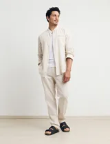 Camisa de cuello mao y manga larga, confeccionada en una mezcla de lino y algodón. Presenta un diseño de corte recto con botones en tono natural y un bolsillo pequeño en el pecho.