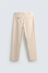 Pantalón chino de corte recto confeccionado en tejido ligero de algodón con estructura canvas. Presenta bolsillos frontales, bolsillos traseros de vivo y cierre frontal con cremallera y botón.