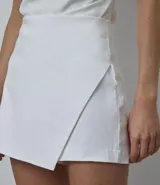 Short pollera corto de tiro alto, confeccionado en bengalina, con diseño de recorte delantero y cierre invisible en la parte posterior.