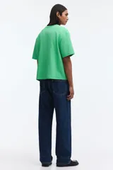 Remera boxy de algodón en color verde, con hombros caídos, cuello redondo acanalado y corte oversized.
