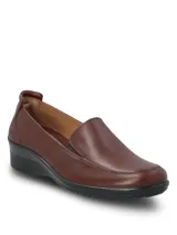 Zapato tipo slip-on de cuero liso lustrado color marrón, con diseño de calce fácil y suela de caucho termoplástico con taco de 4 cm.