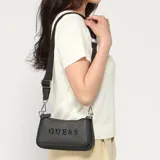 Bolso bandolera Guess modelo Holly, color negro con estampado de monograma y el logo de la marca en el frente. Cuenta con diseño multi-compartimento con cierres y correa ajustable de lona con la marca grabada.