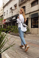 Championes de estilo urbano en color blanco con detalles en tono arena. Presentan un diseño con doble tira de velcro en el empeine, suela de plataforma dentada en color caramelo y tirador en el talón.