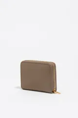 Billetera compacta de estructura blanda con cierre de cremallera perimetral. Presenta el logo metálico de la marca en el frente y acabados metálicos dorados.