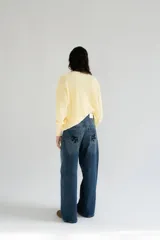 Jean wide leg de tiro medio, color azul con lavado denim, con bolsillos traseros decorados con una estampa floral oscura.