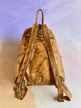 Mochila Lucy de cuero color terra con efecto desgastado, múltiples bolsillos externos con cierre y herrajes de metal envejecido.