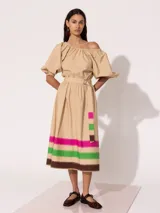 Vestido midi color beige con escote off-shoulder, mangas cortas abullonadas y falda acampanada con estampado de franjas horizontales en colores fucsia, verde y marrón. Incluye cinturón con hebilla.